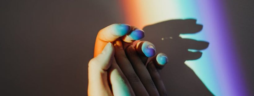 persons hands with rainbow colors