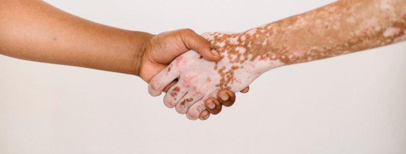 crop faceless men shaking hands in studio