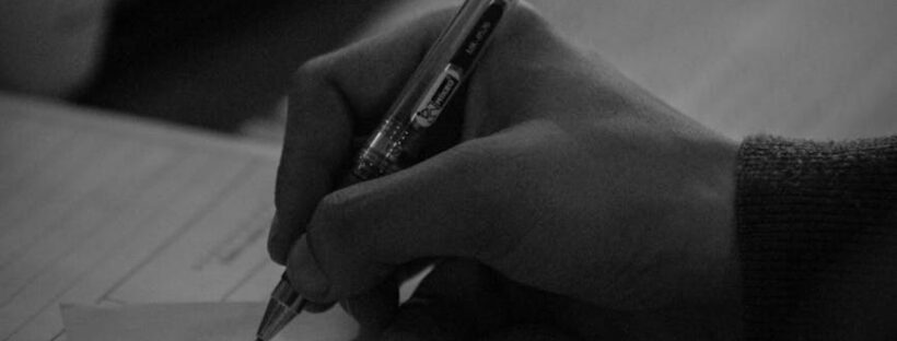 close up of a person writing on paper